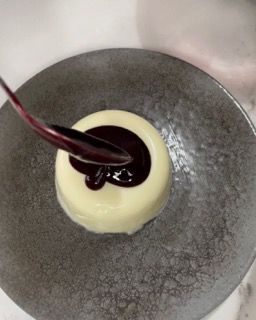 Un primo piano di un dessert su un piatto con un cucchiaio dentro