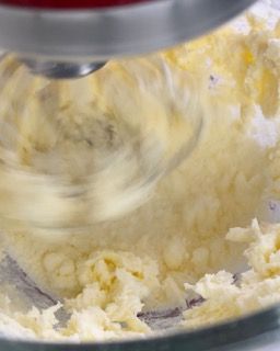 Primo piano di un mixer che prepara la panna montata in una ciotola.