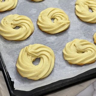 Un vassoio di biscotti glassati gialli su carta oleata