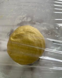 Una palla di pasta è avvolta nella pellicola trasparente.