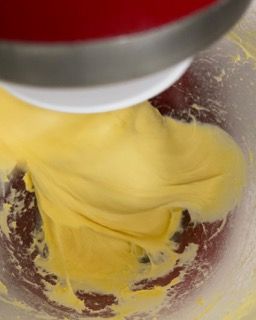 Un mixer sta mescolando un liquido giallo in una ciotola di vetro.