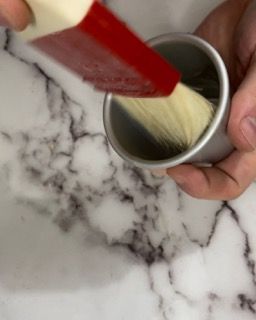 Una persona tiene in mano una tazza con dentro uno spazzolino.