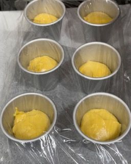 Un mucchio di tazze di metallo piene di liquido giallo