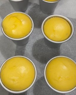 Un mazzo di palline gialle in tazze bianche su un tavolo