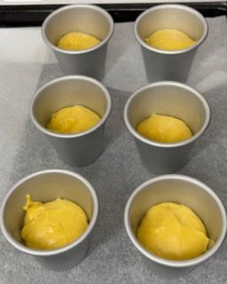 Un mucchio di tazze piene di liquido giallo su un tavolo