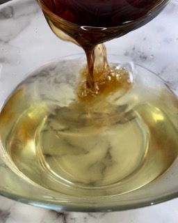 Lo sciroppo viene versato in una ciotola di vetro.