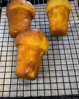 Tre cupcake sono appoggiati su una griglia di raffreddamento