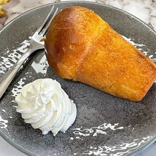 Un pezzo di torta con panna montata e una forchetta su un piatto