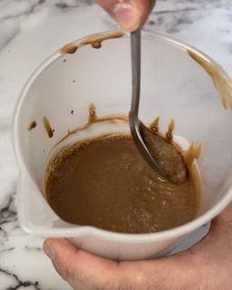 Una persona sta mescolando qualcosa in una ciotola con un cucchiaio