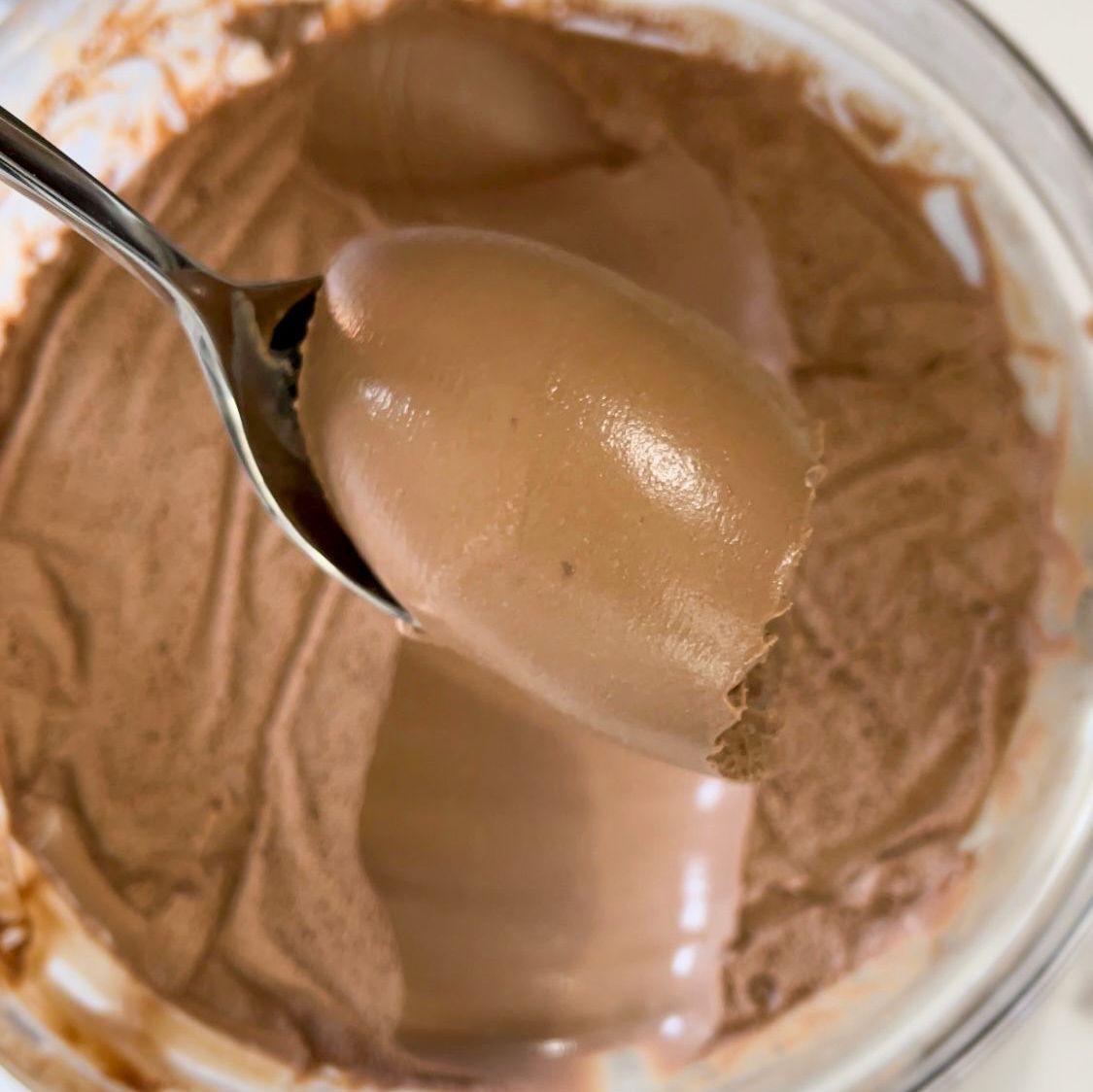 Una ciotola di budino al cioccolato con un cucchiaio dentro