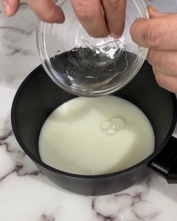 Una persona sta versando del liquido in una ciotola.