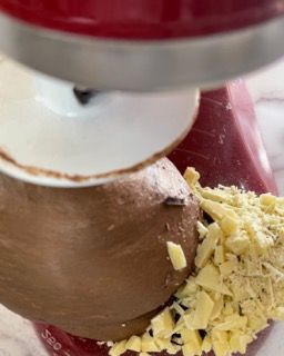 Un mixer rosso viene utilizzato per preparare una torta al cioccolato