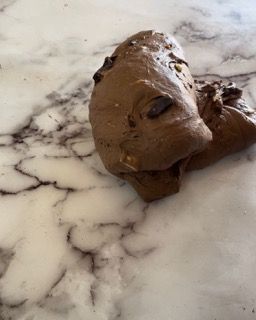Primo piano di un pezzo di pasta al cioccolato su una superficie di marmo.