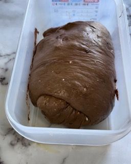 Una pagnotta di pane al cioccolato è in un contenitore di plastica.