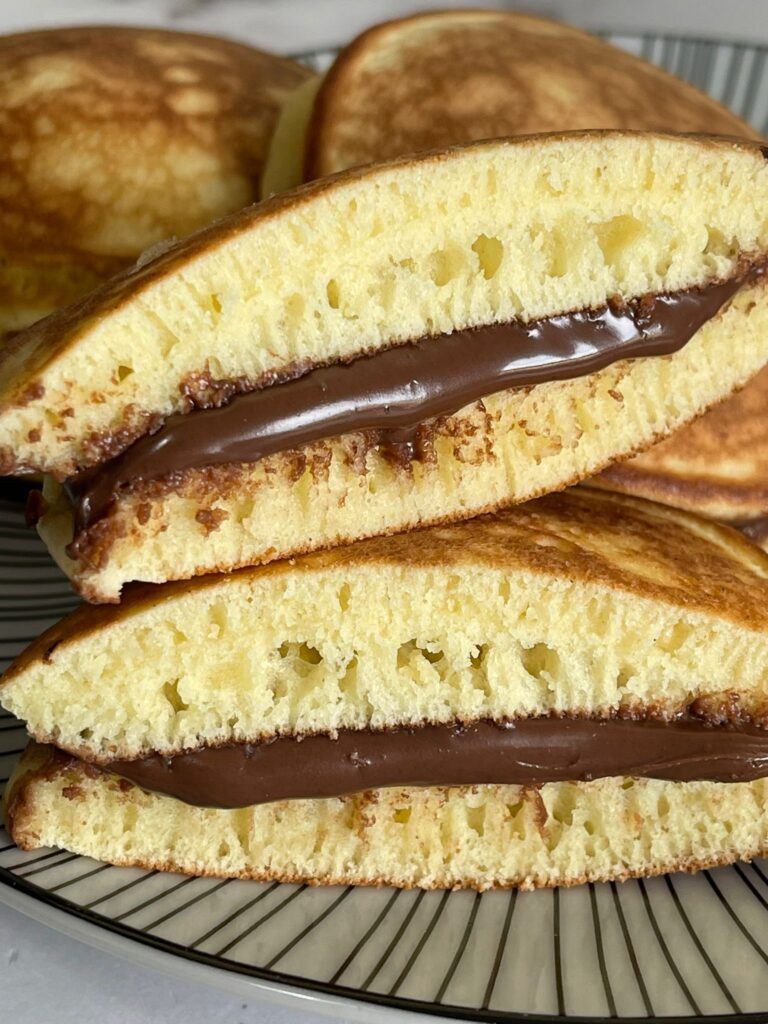 Primo piano di una pila di pancake con salsa al cioccolato su un piatto.