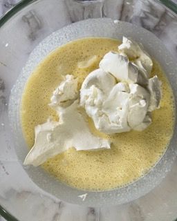 Primo piano di una ciotola di uova e panna montata.