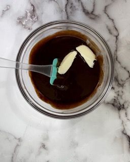 Una ciotola di salsa con aglio e un cucchiaio dentro.