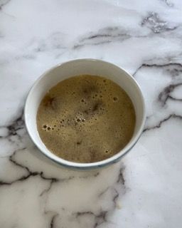 Una ciotola di zuppa è appoggiata su una superficie di marmo.