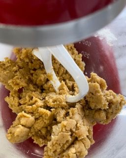 Un mixer sta mescolando una sostanza marrone in una tazza graduata