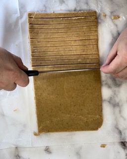 Una persona sta tagliando un pezzo di pasta a strisce.