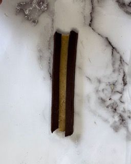 Primo piano di due bastoncini di cioccolato su una superficie di marmo.