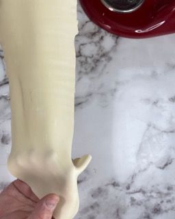 Una persona tiene in mano un pezzo di pasta.