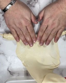 Una persona tiene in mano un pezzo di pasta