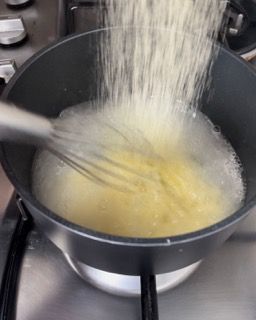 Una persona sta sbattendo qualcosa in una pentola sul fornello