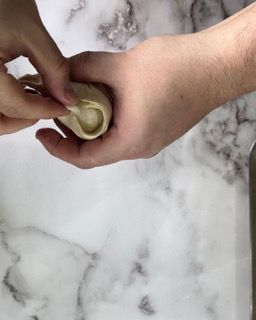 Una persona tiene in mano un pezzo di pasta.