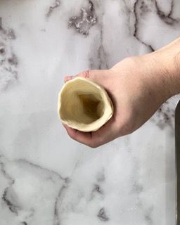 Una persona tiene in mano un pezzo di pasta.