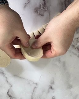 Una persona tiene in mano un pezzo di pasta.