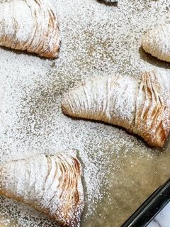 Un vassoio di pasticcini ricoperti di zucchero a velo su un tavolo.