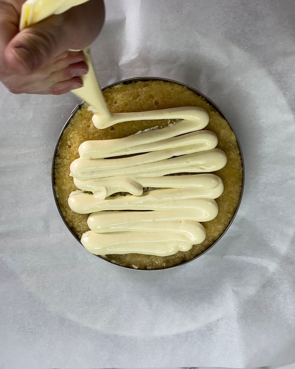 Una persona sta glassando una torta con una sac à poche