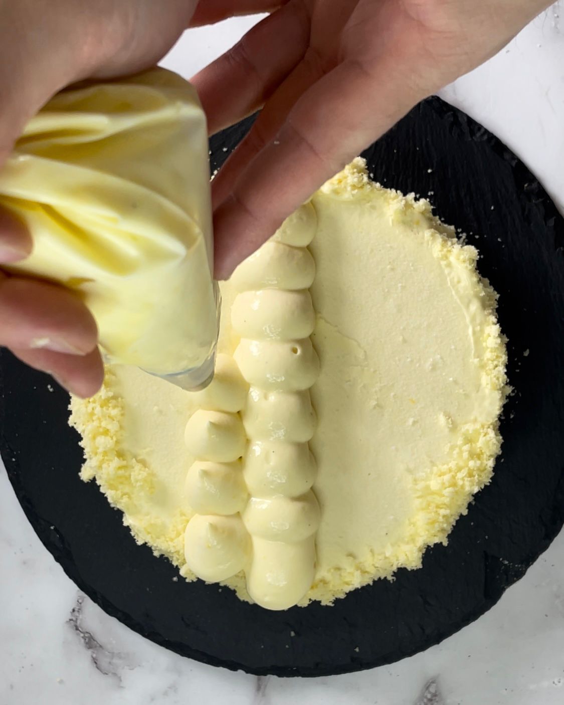 Una persona sta glassando una torta con una sac à poche.