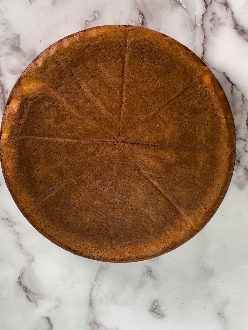 Una pizza viene tagliata a fette su una superficie di marmo.