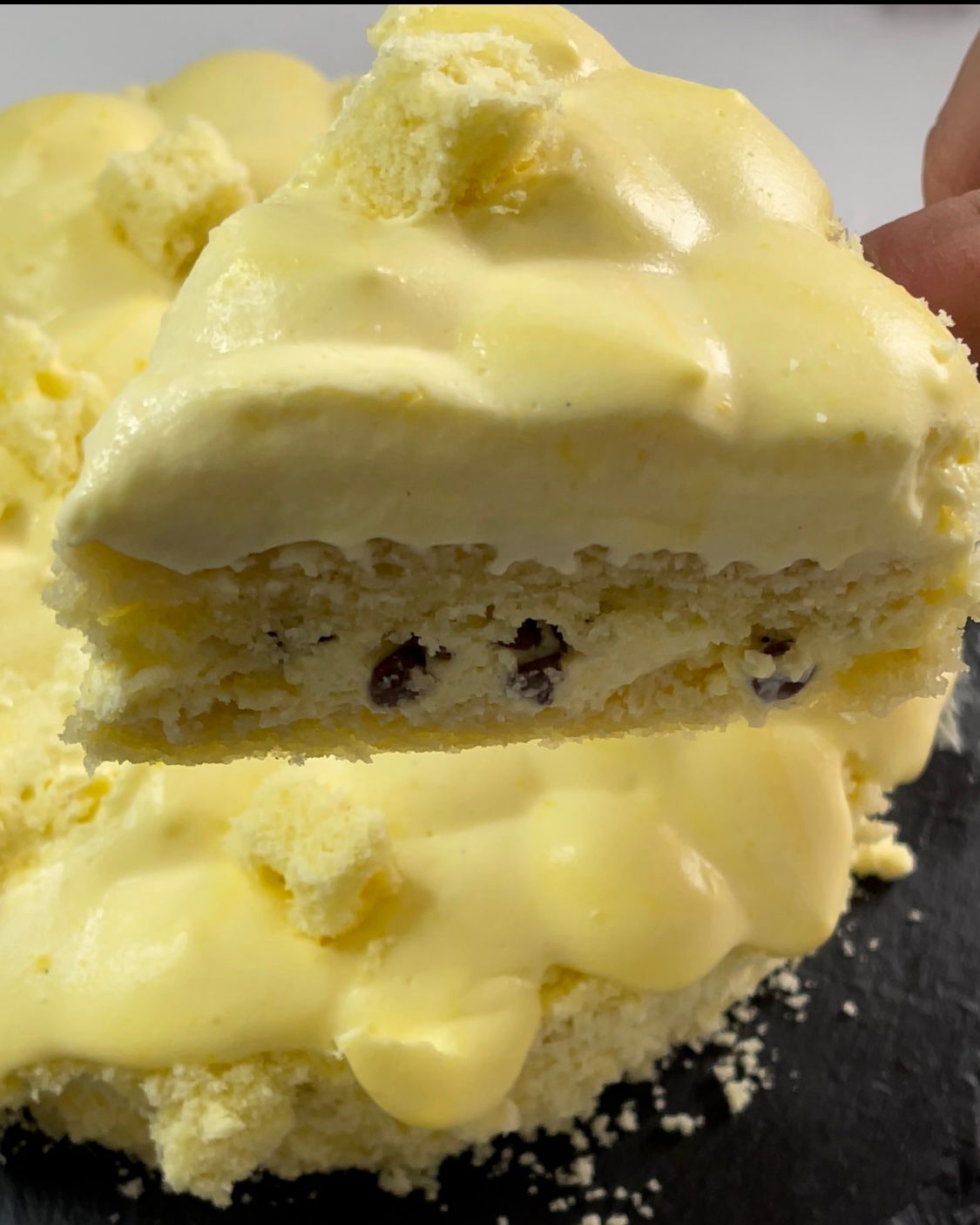 Una persona tiene in mano un pezzo di torta a cui è stato staccato un morso.