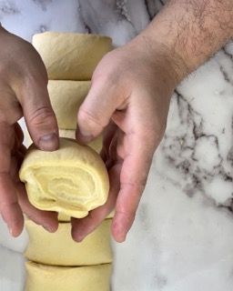 Una persona tiene in mano un pezzo di pasta.