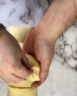 Una persona tiene in mano un pezzo di pasta.