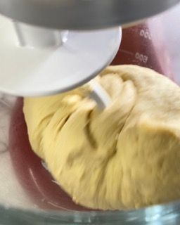 Primo piano di un impasto in un misurino mentre viene mescolato con un mixer.