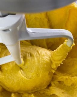 Un primo piano di un mixer con dentro una pastella gialla