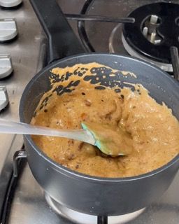 Una pentola di zuppa con un cucchiaio dentro su un fornello