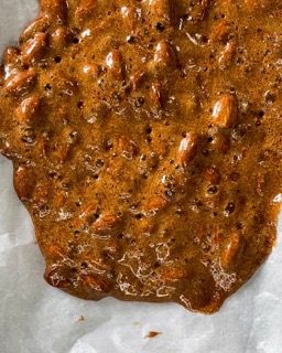 Un primo piano di una salsa marrone con noci dentro