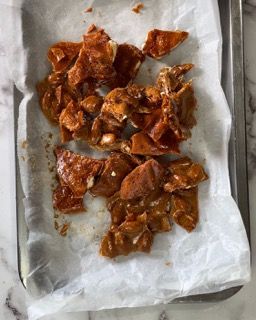 Un vassoio di cibo è appoggiato su un pezzo di carta su un tavolo.