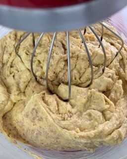 Un primo piano di una ciotola di pastella con una frusta dentro