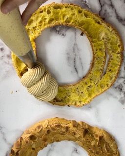 Una persona sta glassando una ciambella con una sac à poche