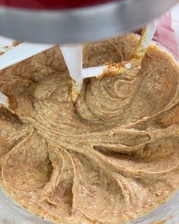 Primo piano di un mixer che mescola un liquido marrone in una ciotola.