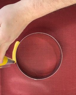 Una persona sta tagliando un cerchio con un paio di forbici.