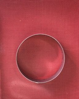 Un cerchio è appoggiato su una superficie rossa.