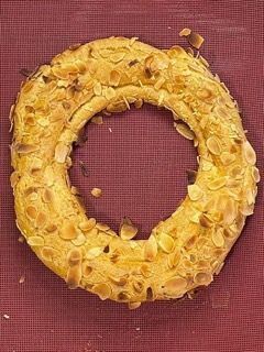 Una corona di pane con sopra delle mandorle su un tavolo.