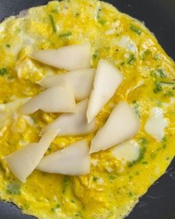 Un primo piano di una frittata con fette di formaggio sopra